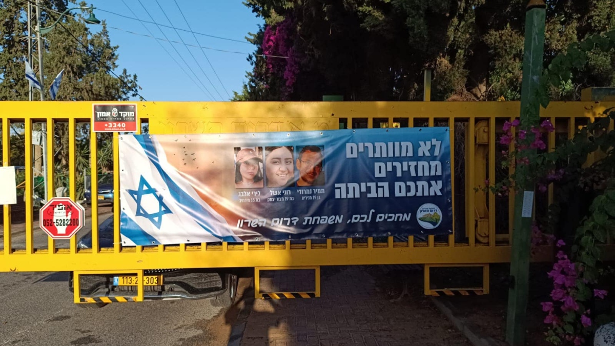 תמונה של כרזה למען שחרור החטופים תלויה בכניסות ליישובי המועצה השונים